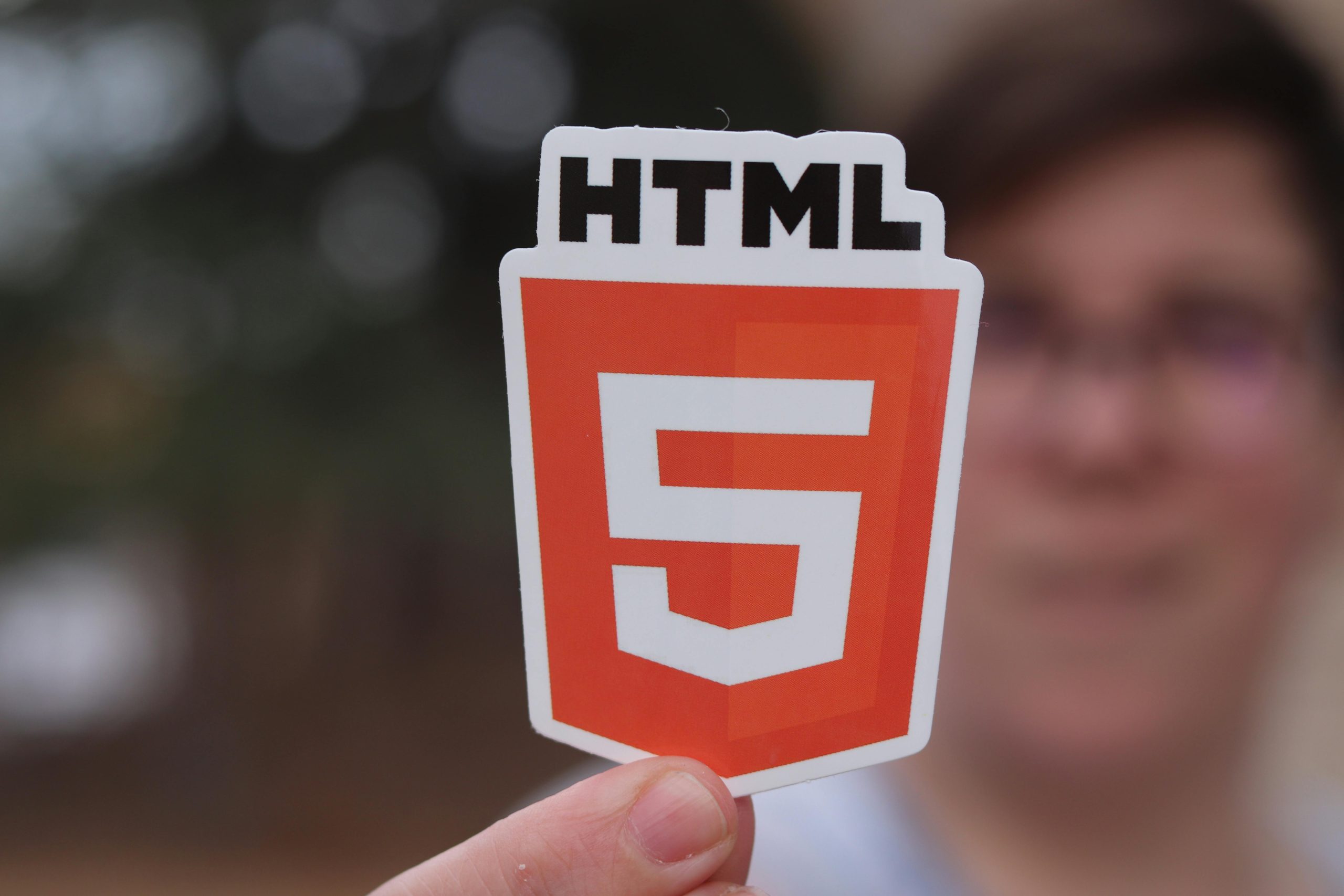 Man Holding a Paper Cutout with the HTML5 Logo